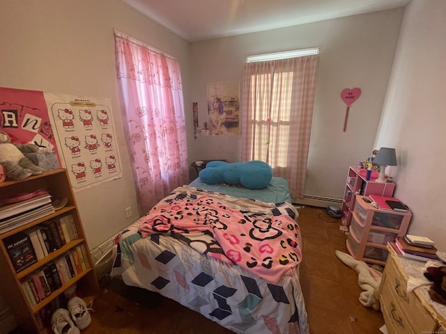 bedroom with dark tile patterned flooring and a baseboard heating unit