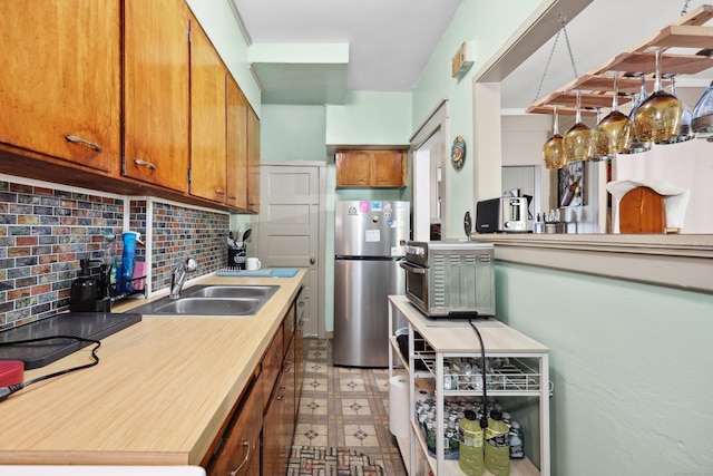 45 Ives St, Waterbury, CT 06704 - kitchen featuring freestanding refrigerator, decorative backsplash, light countertops, brown cabinetry, and light floors