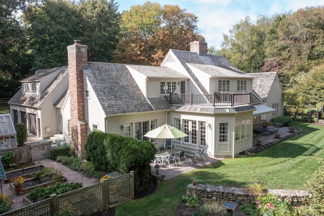 back of house with a lawn, a balcony, and a patio