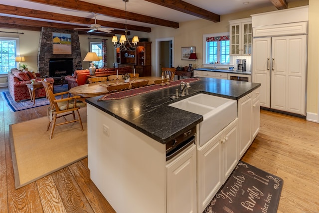 kitchen featuring white cabinetry, an island with sink, and light hardwood / wood-style floors