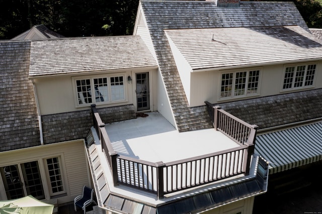 back of property featuring a chimney and a balcony