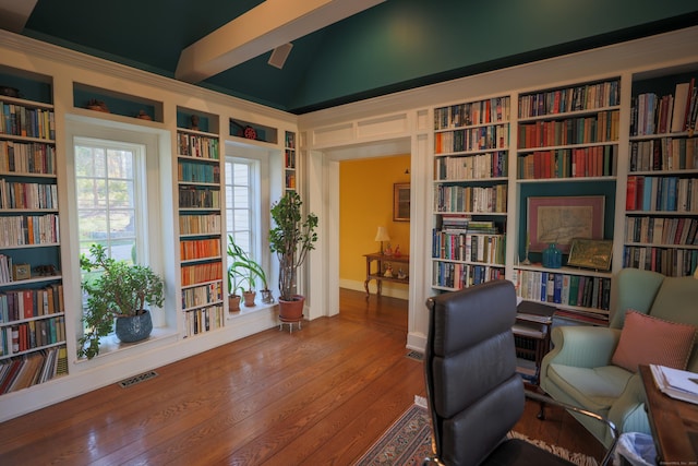 sitting room featuring visible vents, bookshelves, built in shelves, and vaulted ceiling