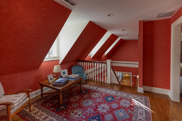 additional living space with vaulted ceiling and hardwood / wood-style flooring