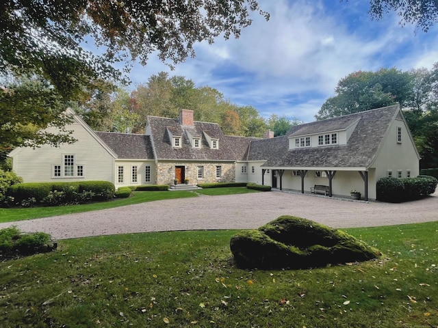 cape cod house featuring a front lawn