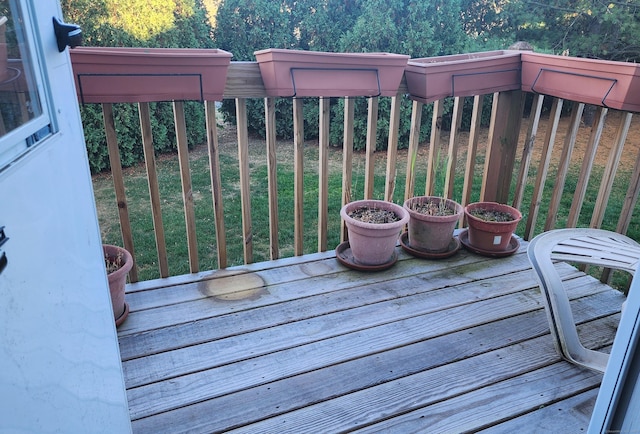 wooden terrace featuring a lawn