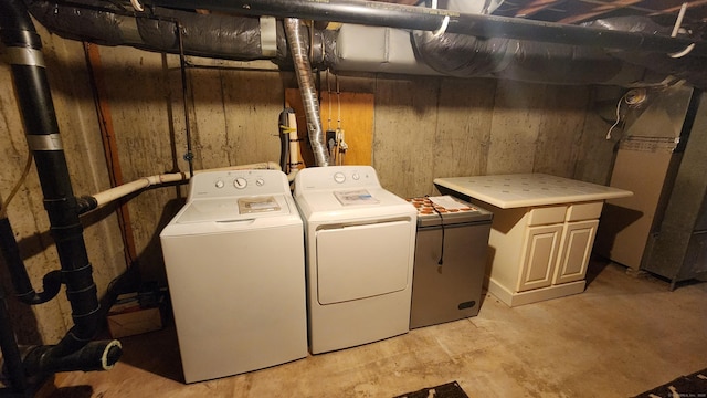 laundry room with separate washer and dryer and cabinets