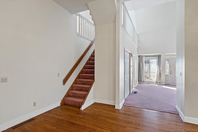 entrance foyer with a towering ceiling and dark wood-type flooring