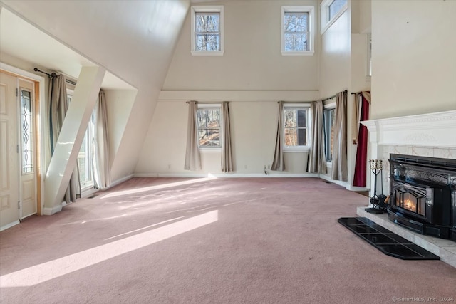 unfurnished living room featuring carpet, a wealth of natural light, and high vaulted ceiling