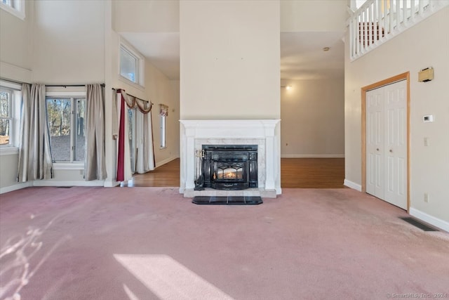 unfurnished living room with a high ceiling and carpet flooring