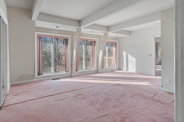 unfurnished living room with a textured ceiling, light carpet, and beam ceiling