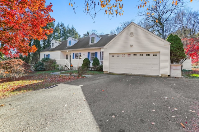 cape cod home featuring a garage