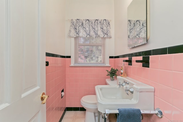 bathroom featuring sink, tile patterned flooring, tile walls, and toilet