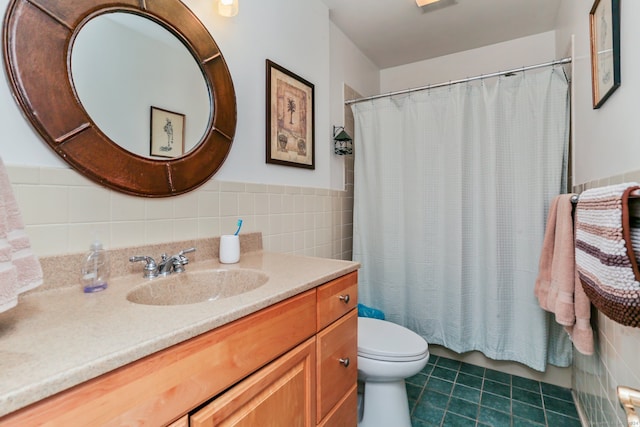 bathroom with vanity, tile walls, tile patterned flooring, toilet, and curtained shower