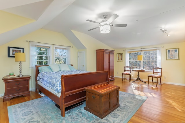 bedroom with hardwood / wood-style flooring, multiple windows, lofted ceiling, and ceiling fan