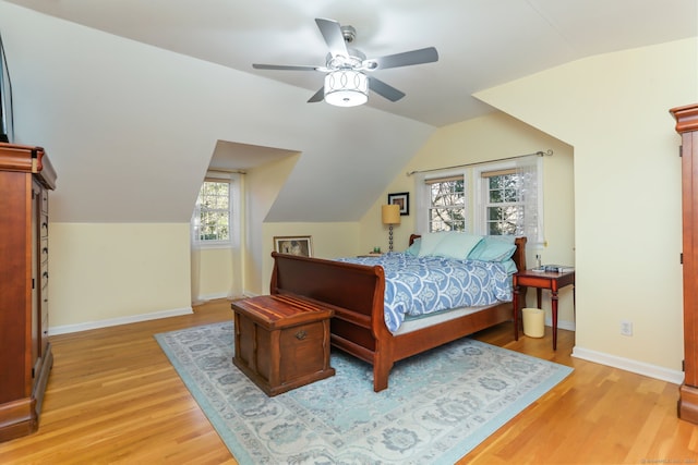 bedroom with ceiling fan, lofted ceiling, and light wood-type flooring