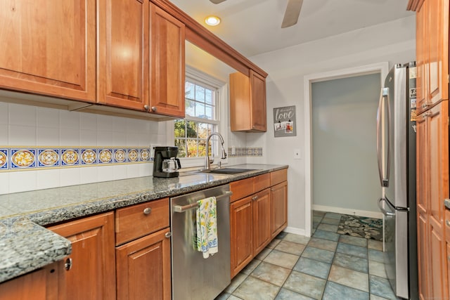 kitchen with appliances with stainless steel finishes, tasteful backsplash, dark stone countertops, and sink