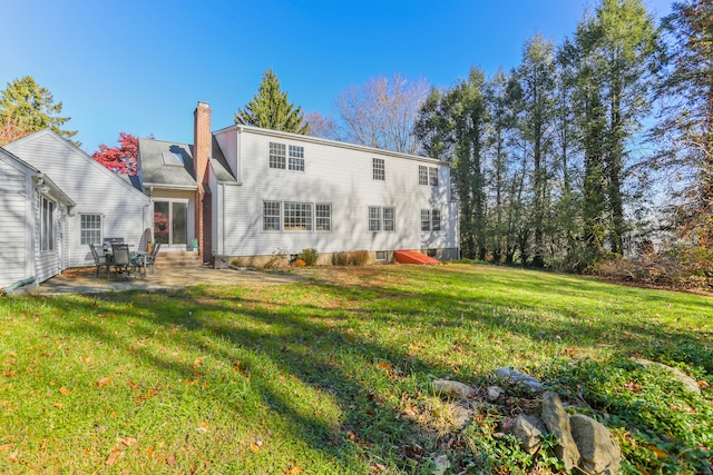 rear view of house featuring a patio area and a yard