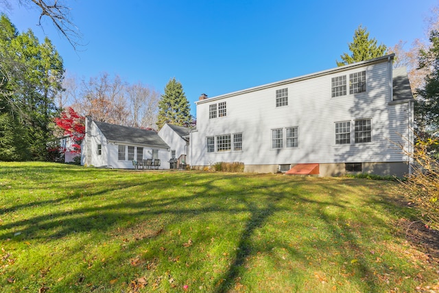 back of house with a lawn