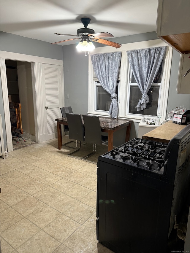 kitchen with ceiling fan and black range