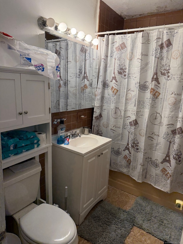 bathroom with vanity, toilet, and a textured ceiling