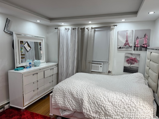 bedroom with dark wood-type flooring, cooling unit, and a raised ceiling