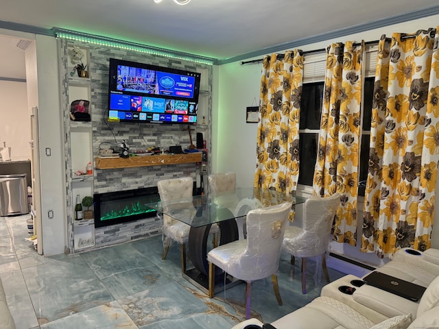 living room with a fireplace, a baseboard radiator, and crown molding