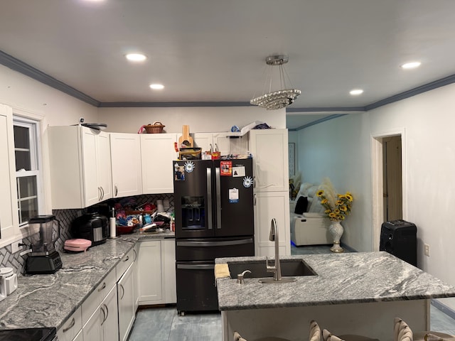 kitchen with light stone counters, white cabinets, sink, tasteful backsplash, and black fridge with ice dispenser