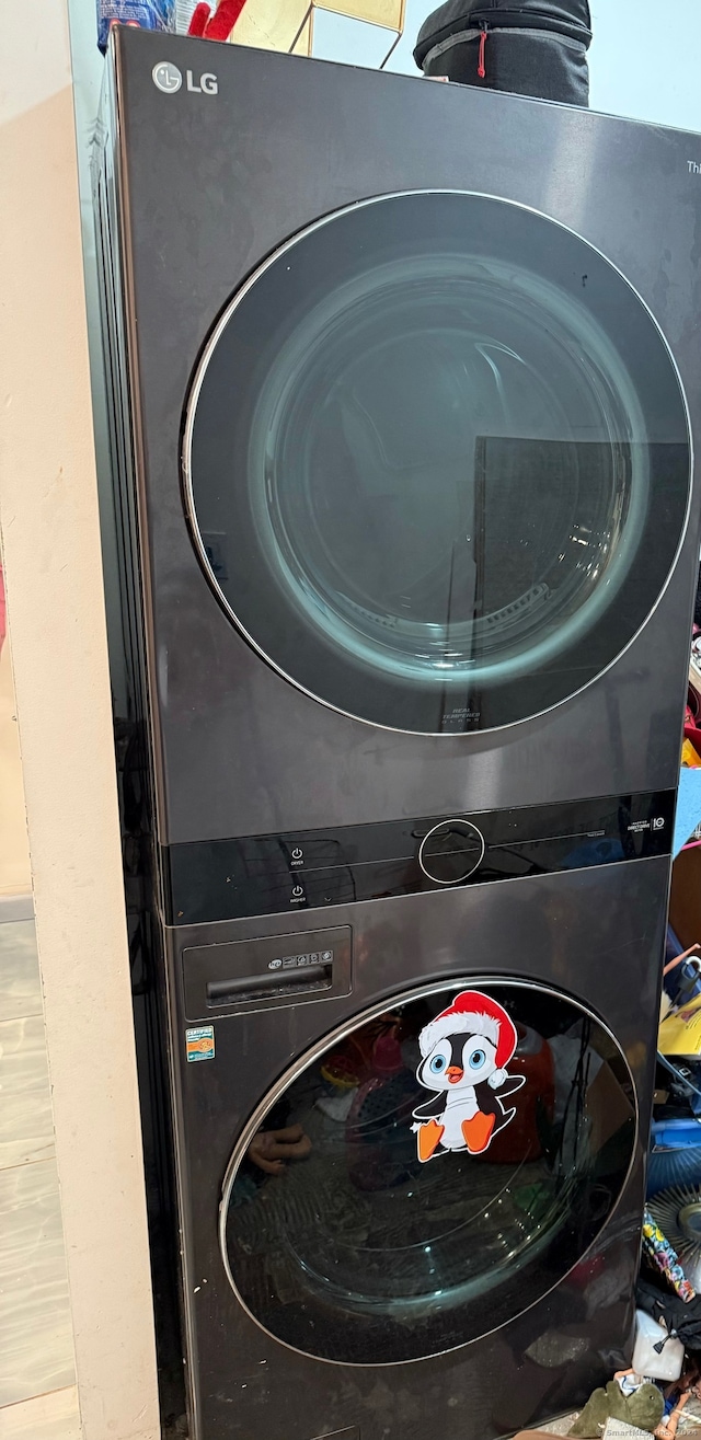 washroom featuring stacked washer and clothes dryer