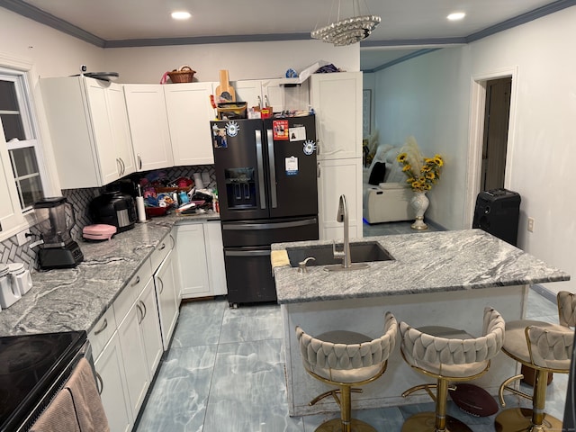 kitchen featuring black refrigerator with ice dispenser, tasteful backsplash, sink, and white cabinets