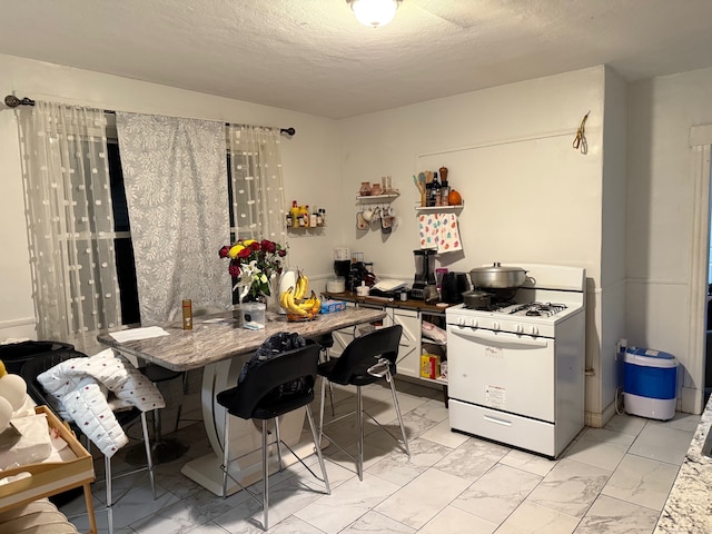 kitchen featuring a textured ceiling and white gas range