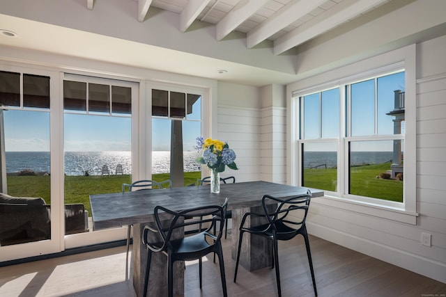 sunroom featuring beamed ceiling, a water view, and plenty of natural light