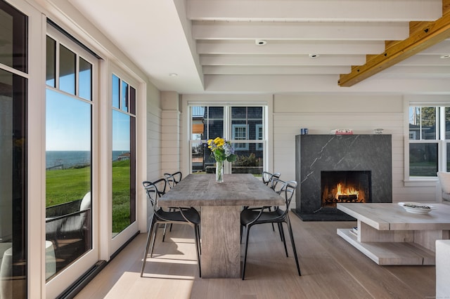 sunroom with beam ceiling and a premium fireplace