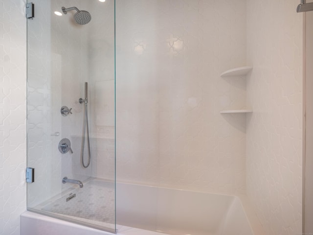 bathroom with bath / shower combo with glass door