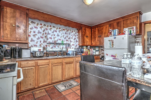 kitchen with sink, refrigerator, and white stove