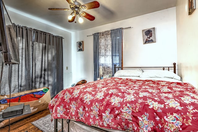 bedroom with dark hardwood / wood-style flooring and ceiling fan