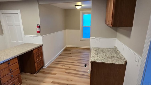 kitchen with built in desk and light wood-type flooring