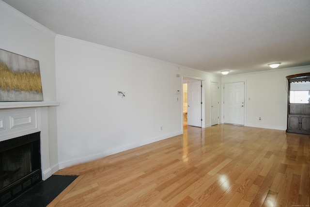 unfurnished living room featuring ornamental molding and hardwood / wood-style flooring