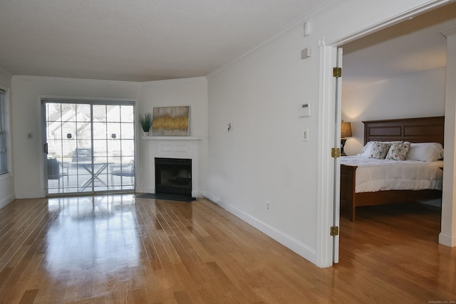 unfurnished living room featuring hardwood / wood-style floors and ornamental molding