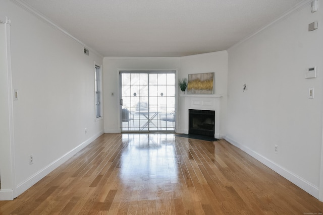 unfurnished living room featuring crown molding and light hardwood / wood-style flooring