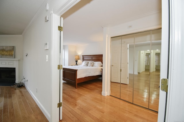 bedroom featuring wood-type flooring, a closet, and crown molding