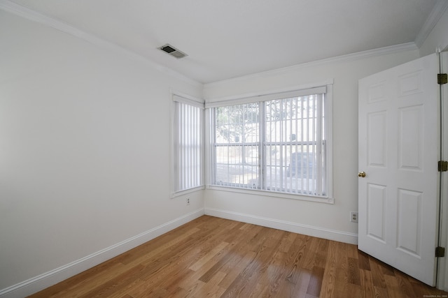 empty room featuring crown molding and hardwood / wood-style floors