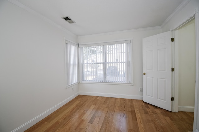 spare room featuring ornamental molding and light hardwood / wood-style flooring