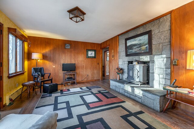 living room featuring hardwood / wood-style flooring, a wood stove, and wooden walls