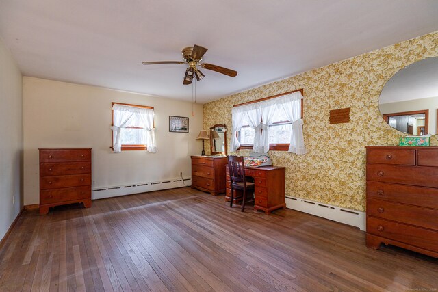 office space with dark hardwood / wood-style floors, a wealth of natural light, and a baseboard heating unit