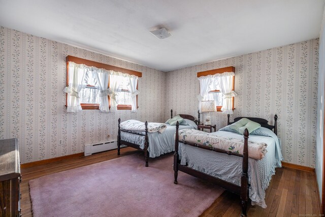 bedroom with baseboard heating and dark wood-type flooring