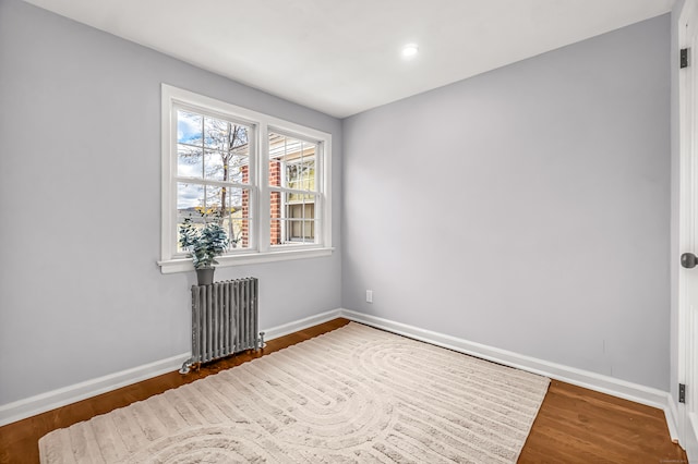 empty room with radiator and dark wood-type flooring