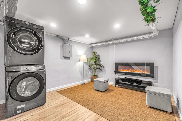 washroom featuring hardwood / wood-style floors and stacked washer / drying machine