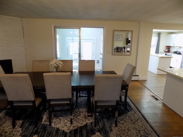 dining space with hardwood / wood-style floors and a healthy amount of sunlight