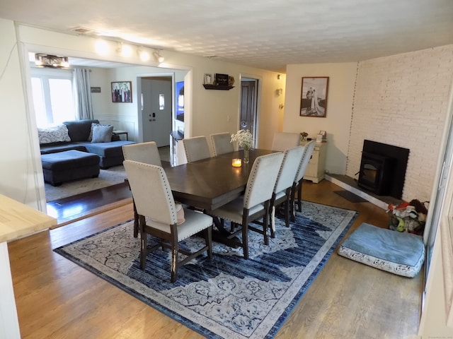 dining area featuring hardwood / wood-style floors and a wood stove