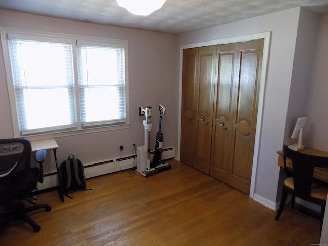 office space with hardwood / wood-style floors, baseboard heating, and a textured ceiling